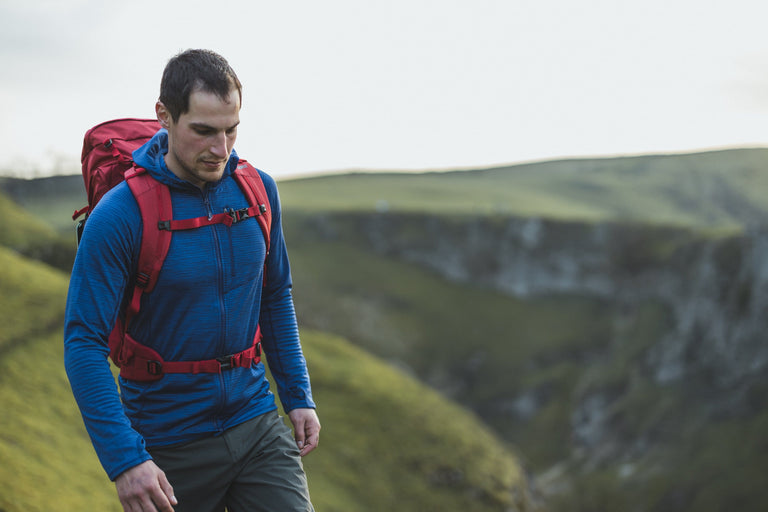 A man hiking in the Peak District in a blue lightweight fleece - action