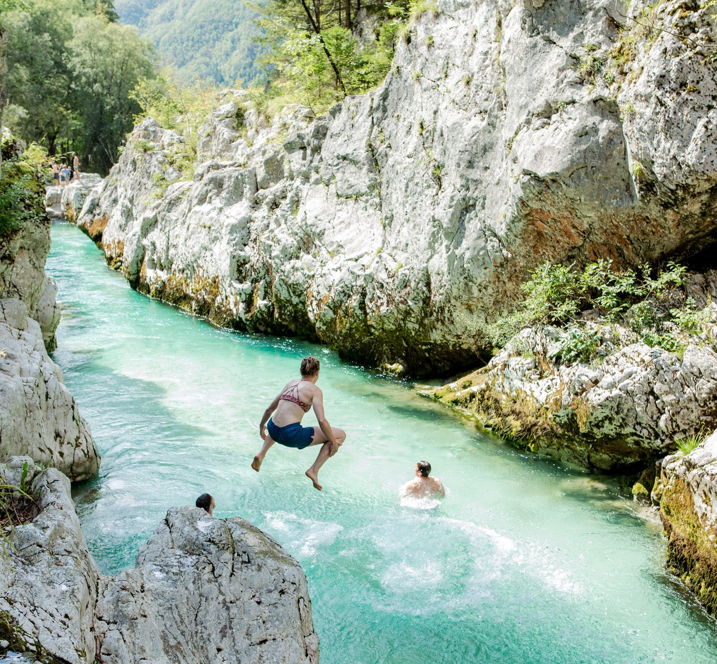 Woman jumping into mountain river