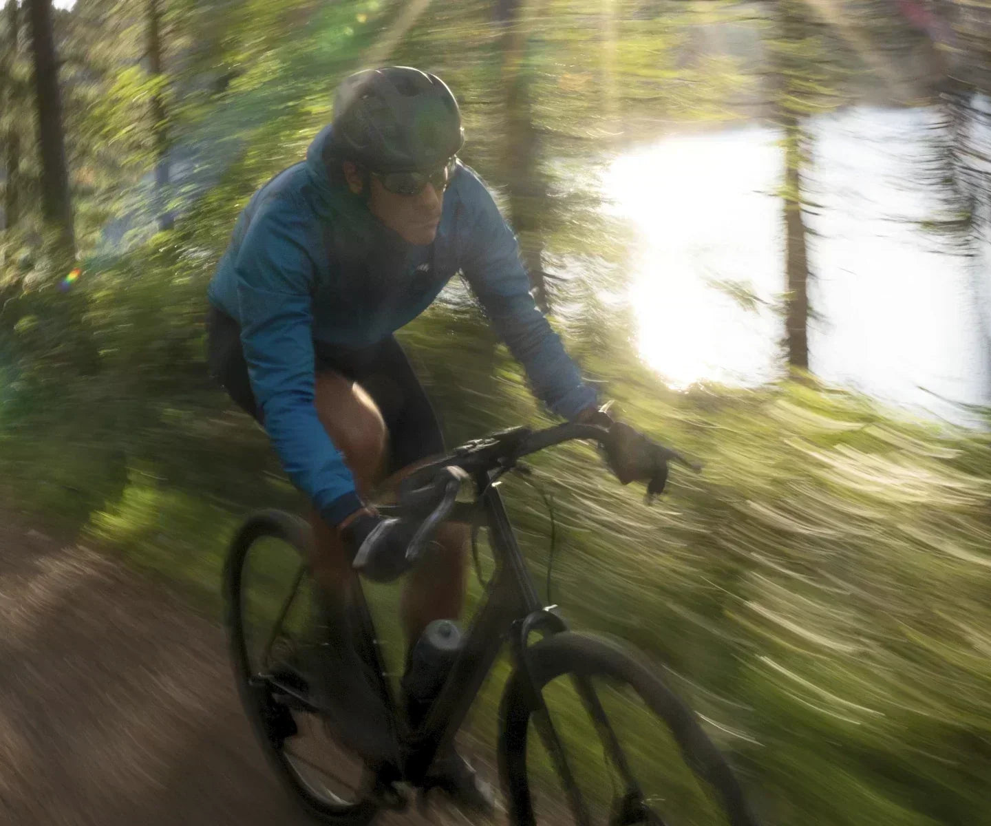 Fast moving e-gravel bike rider next to a lake in the Peak District