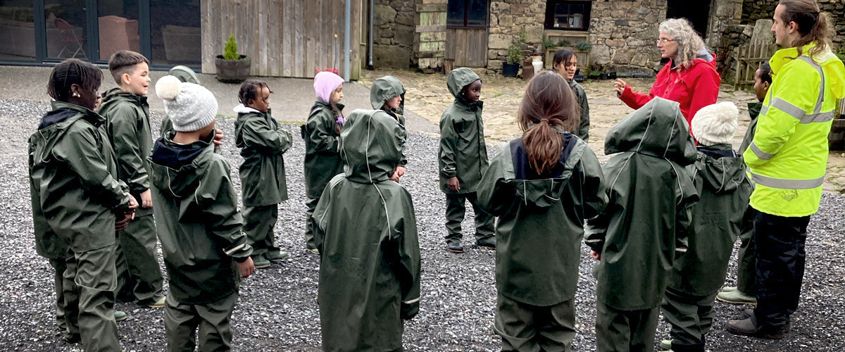 Schoolchildren taking part in farm activities on a visit to a working farm