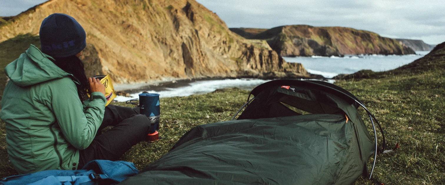 A camper enjoys a lighweight summer bivvy on a clifftop