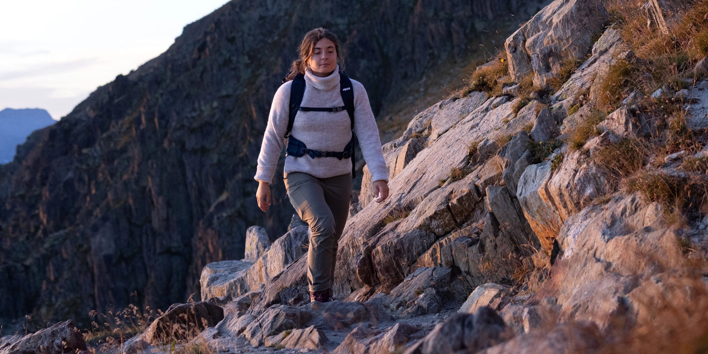 Woman walking in the mountains wearing a wool jumper