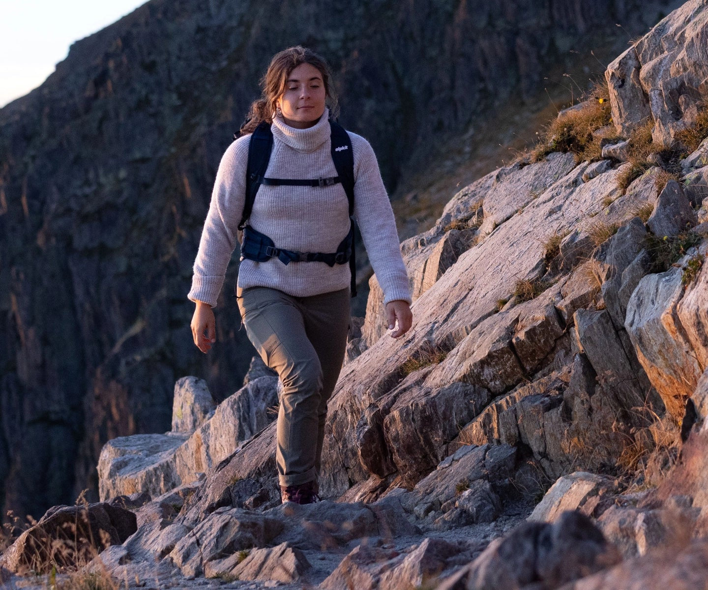 Woman walking in the mountains wearing a wool jumper