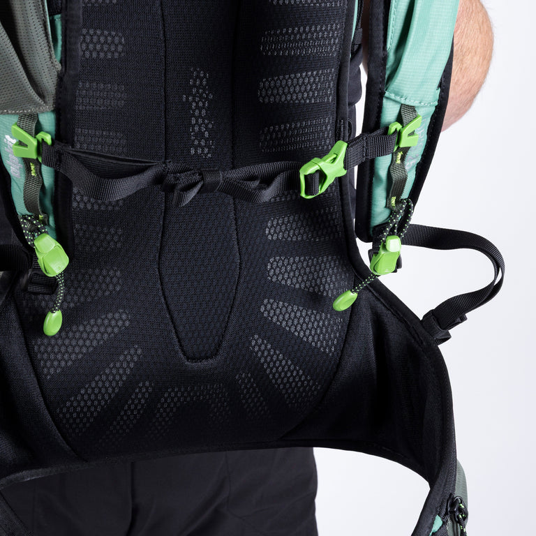 Close-up of a black backpack with green straps on a white background