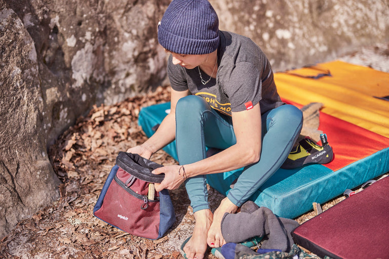 Zofia Reych sitting in a bouldering mat in Font wearing green climbing tights - action - closed