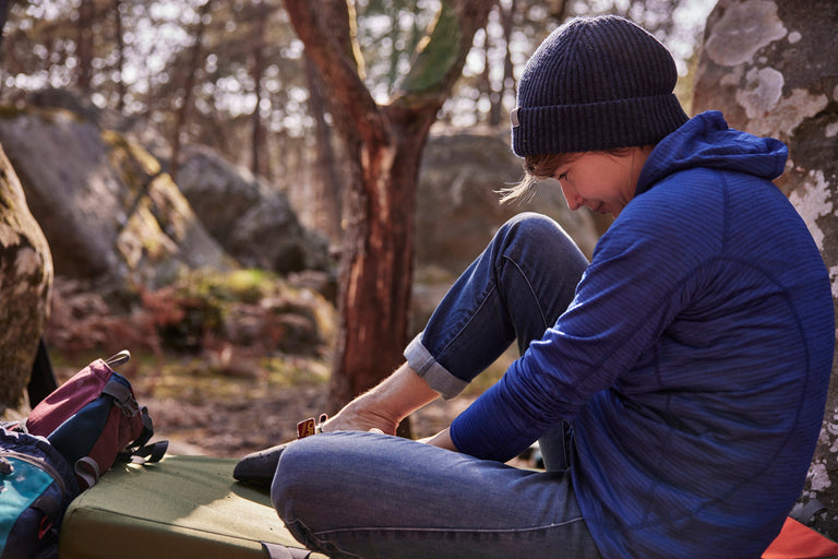 Zofia Reych bouldering in Font wearing a blue hooded fleece - action