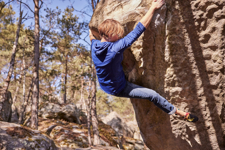 Zofia Reych bouldering in Font wearing a blue hooded fleece - action