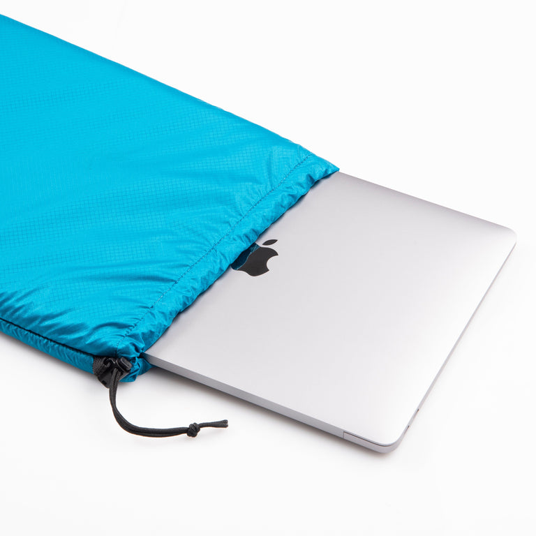 alpkit padded cell 5 fleece lined accessory pouch in blue with macbook