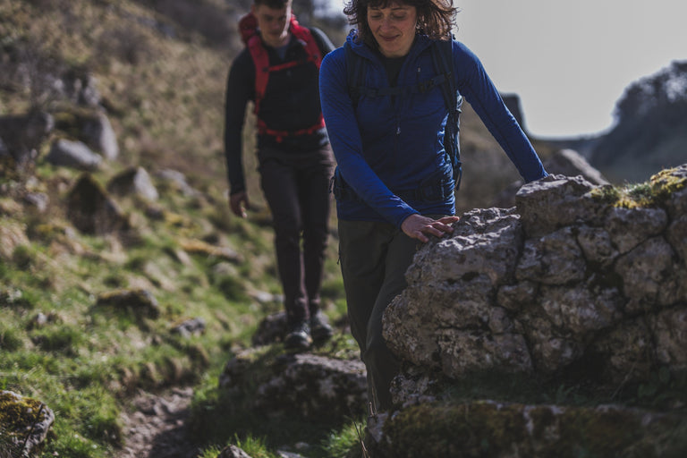 A woman hiking in the Peak District in a blue hooded microfleece - action - closed